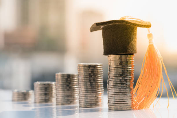 Stack of coins with a graduation hat on top